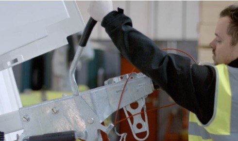 Fig. 65 — Technician operating the handbrake/overrun coupling lever during brake setting preparation. The lever must be in the fully lowered position with the draw tube extended before adjusting the cables