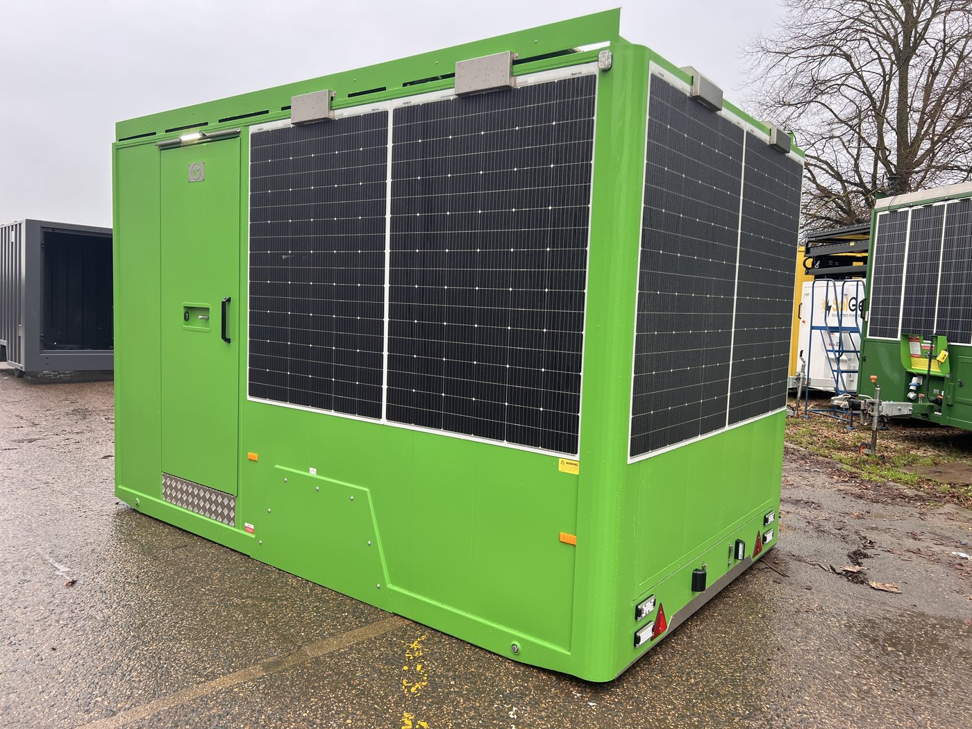 Fig. 5 — Rear left view with the unit deployed and raised on its hydraulic rams, clearly showing the two cylinder legs extended at the base and the wall-mounted solar panels above