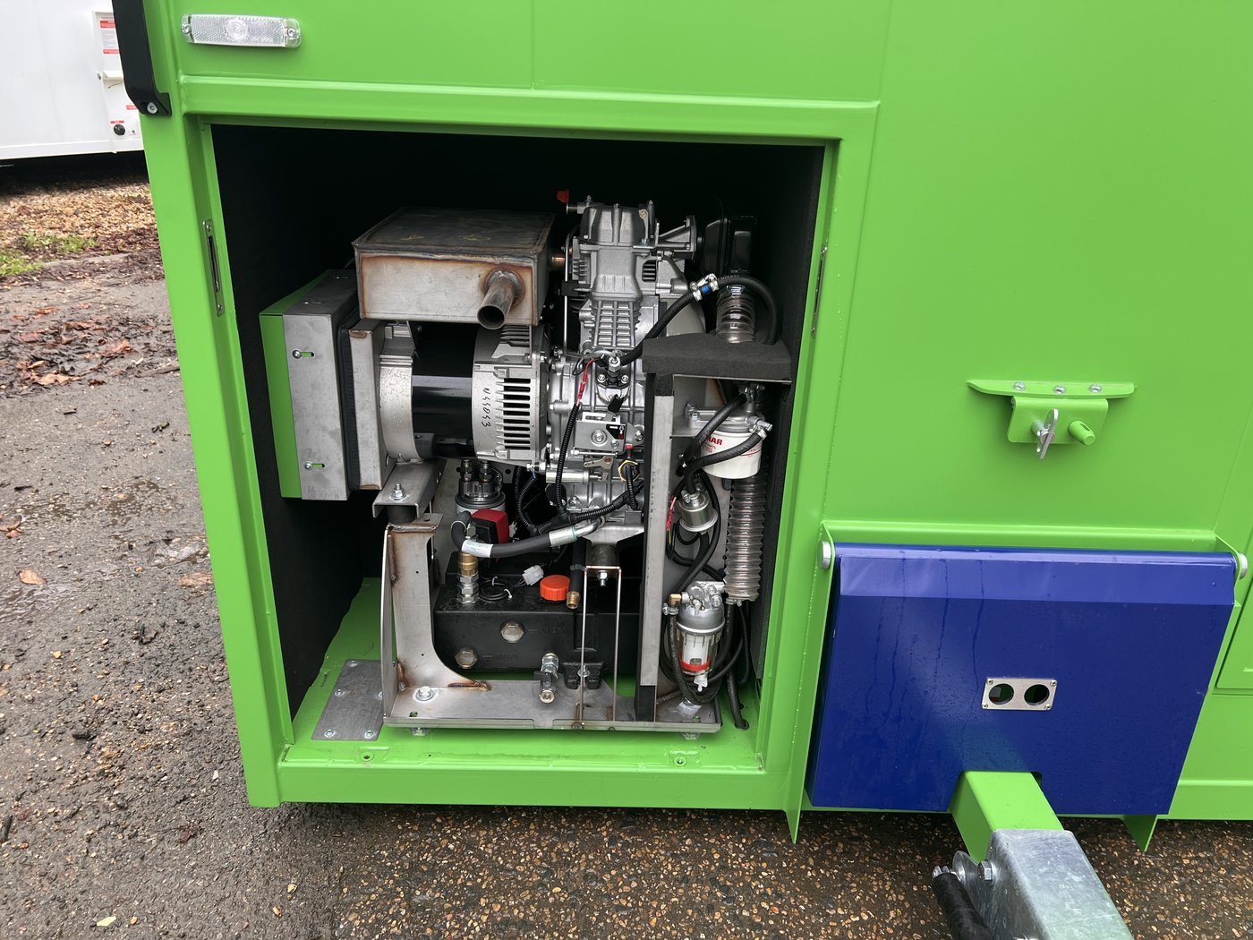 Fig. 24 — Generator compartment with the access cover removed, showing the 6 kVA Infinity generator engine, alternator, and ancillary components. Oil dipstick and filler are accessible from this position