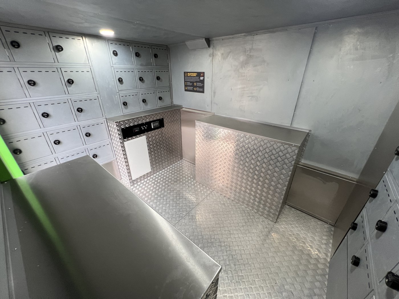 Fig. 15 — Interior from the rear left at a lower angle, giving a clearer view of the counter unit, display screen, right-hand compartment bank, and the chequerplate floor and surfaces throughout