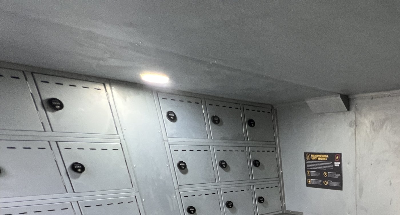 Fig. 48 — Interior PIR ceiling light in situ. The circular LED fitting is recessed into the ceiling above the central aisle. The fire suppression and safety measures notice is visible on the far wall to the right