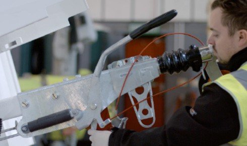 Fig. 63 — Overrun coupling assembly (side view). The overrun coupling connects the tow hitch to the cabin chassis and triggers the brakes when the towing vehicle decelerates. The handbrake lever (black, top), draw tube, brake rod, and cable connections are all visible