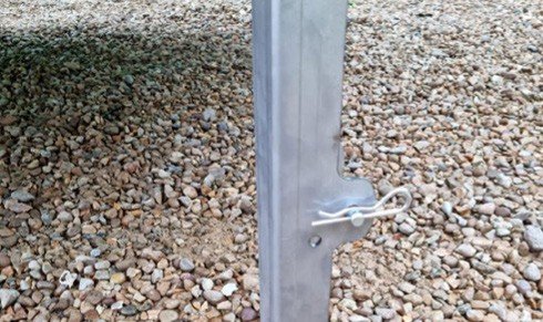 Fig. 56 — Ram prop secured with pin and R-clip (close-up). The pin passes through the holes in the prop; the R-clip locks the pin in place. Verify this on all four corners before working beneath the cabin