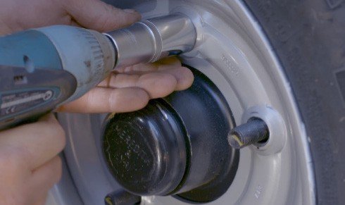 Fig. 61 — Fitting the wheel to the hub: align the wheel studs, push the wheel firmly onto the hub, and hand-tighten the nuts before using the impact driver