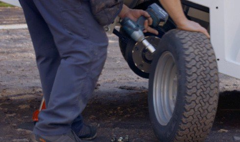Fig. 58 — Wheel nut removal using an impact driver. Loosen all nuts before lifting the wheel clear. Rotate the wheel in the forward direction only during brake-related operations